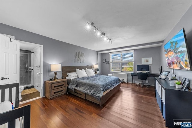 bedroom with rail lighting, ensuite bath, and dark wood-style flooring