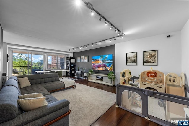 living area with rail lighting and wood finished floors