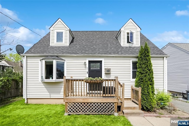 rear view of property featuring a yard, a deck, roof with shingles, and fence