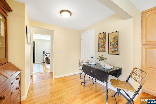 dining space with light wood finished floors and baseboards