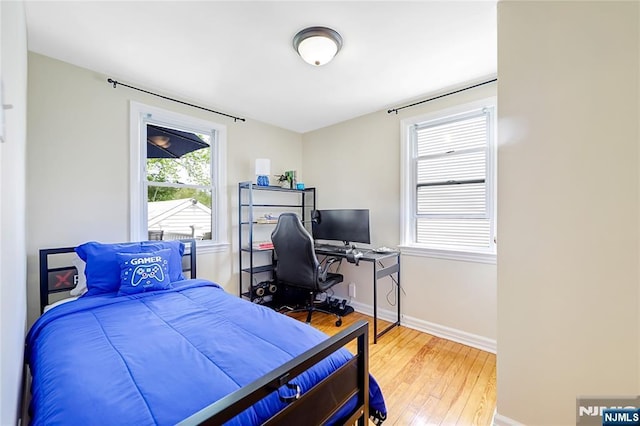 bedroom featuring baseboards and wood-type flooring