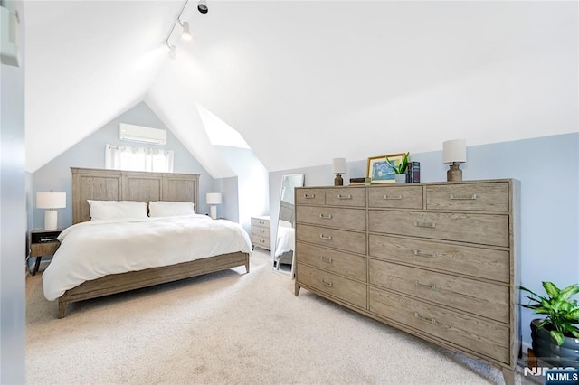 bedroom with lofted ceiling, a wall unit AC, light colored carpet, and track lighting