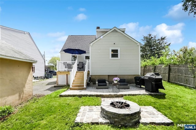 back of house with a deck, fence, a yard, a patio, and a chimney