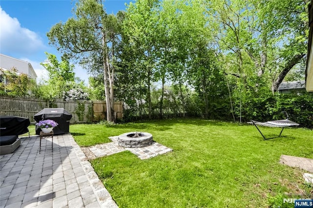 view of yard with a fire pit, a patio area, and fence