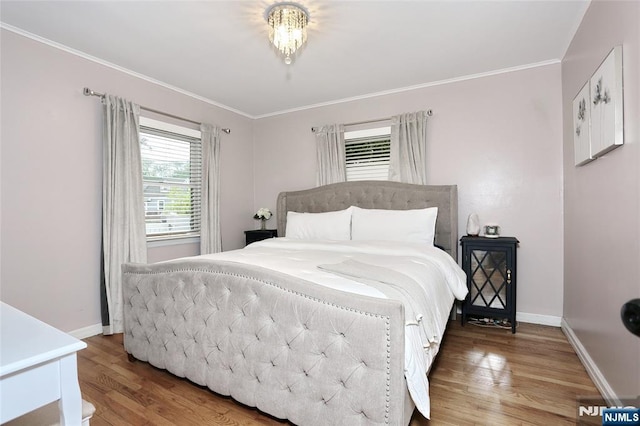 bedroom featuring wood finished floors, baseboards, and ornamental molding