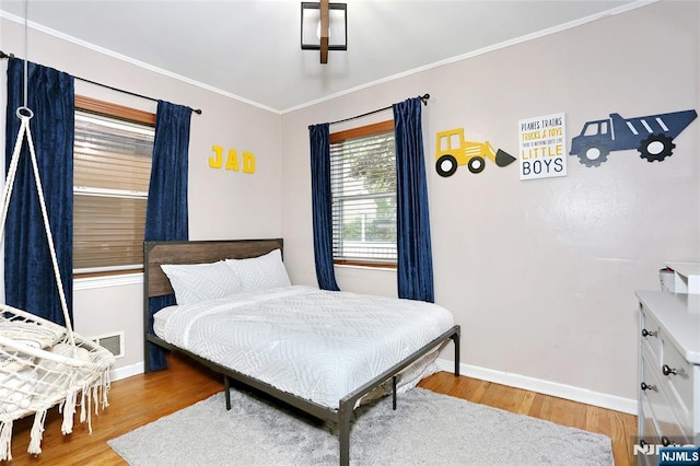 bedroom with baseboards, light wood-type flooring, and crown molding