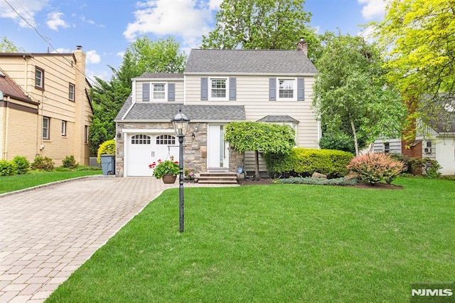 109 Lexington Ave, Cresskill, NJ 07626 - view of front facade featuring decorative driveway, stone siding, a front yard, a shingled roof, and a chimney