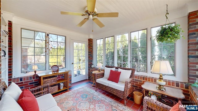 sunroom featuring healthy amount of natural light, french doors, wood finished floors, and brick wall
