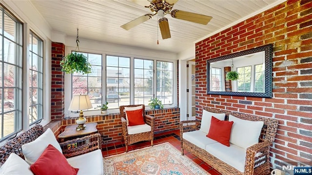 sunroom with brick wall, healthy amount of natural light, an outdoor living space, and ceiling fan