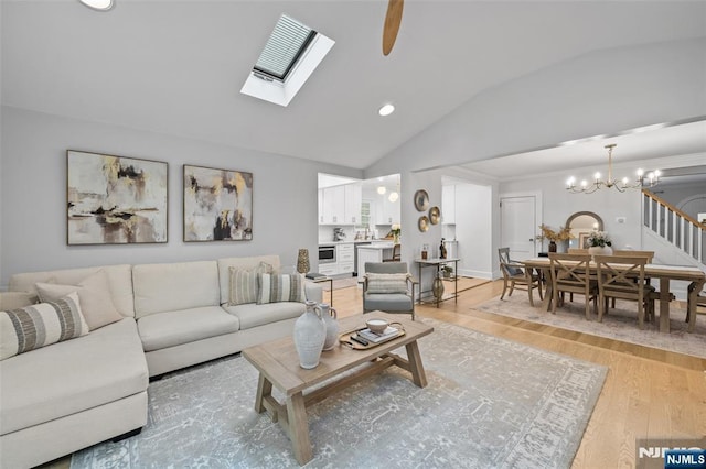 living room with lofted ceiling, light wood-type flooring, recessed lighting, and a chandelier