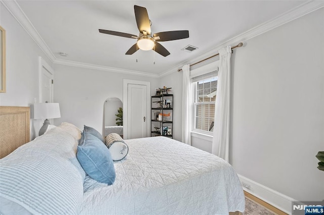 bedroom featuring ornamental molding, wood finished floors, baseboards, and a ceiling fan