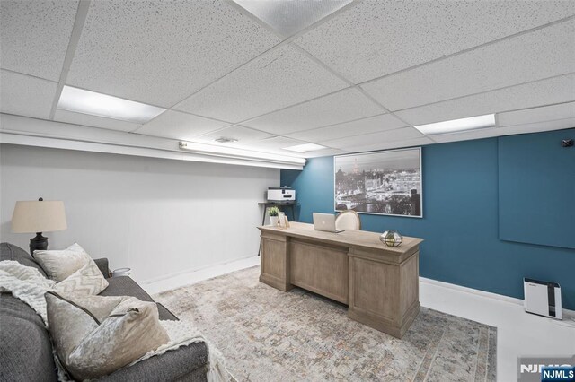 office featuring a paneled ceiling and baseboards
