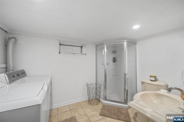 bathroom with washing machine and dryer, a stall shower, a sink, tile patterned flooring, and recessed lighting
