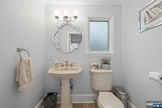 bathroom with toilet, baseboards, and ornamental molding