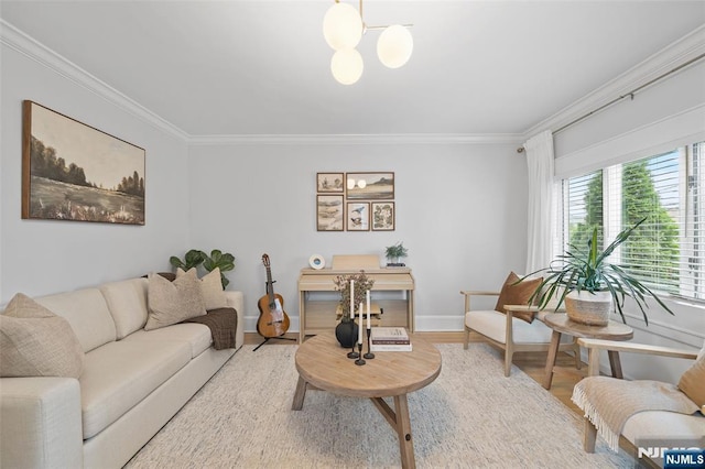 living area featuring ornamental molding, wood finished floors, a chandelier, and baseboards