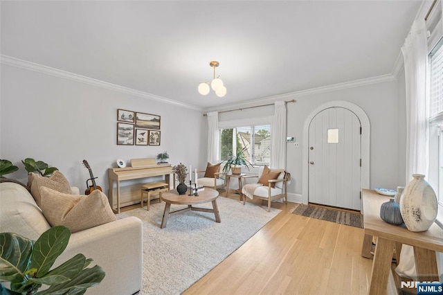 living room with ornamental molding, light wood-style flooring, and baseboards