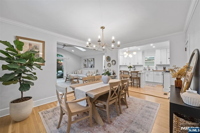 dining space featuring a chandelier, light wood-style flooring, crown molding, a ceiling fan, and baseboards
