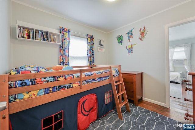 bedroom featuring wood finished floors, ornamental molding, and baseboards