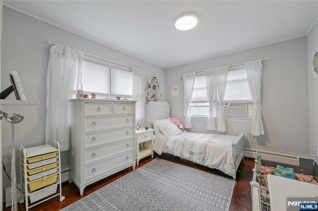 bedroom with a baseboard heating unit, dark wood-style floors, and cooling unit