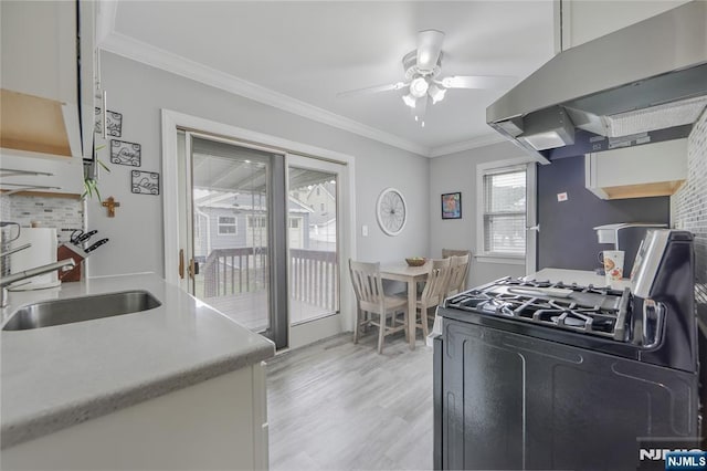 kitchen featuring extractor fan, a sink, range with gas stovetop, a ceiling fan, and decorative backsplash