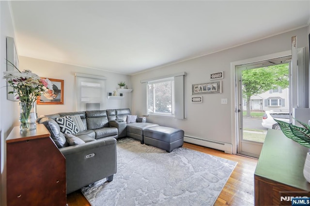 living area with a baseboard radiator, wood finished floors, and crown molding