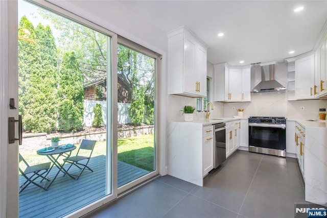 434 Argyle St, Oradell, NJ 07649 - kitchen featuring wall chimney exhaust hood, stainless steel appliances, light countertops, dark tile patterned floors, and white cabinets