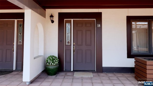 doorway to property with stucco siding and a porch