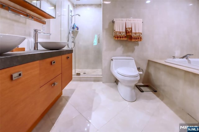 bathroom with a stall shower, vanity, toilet, a bath, and tile patterned floors