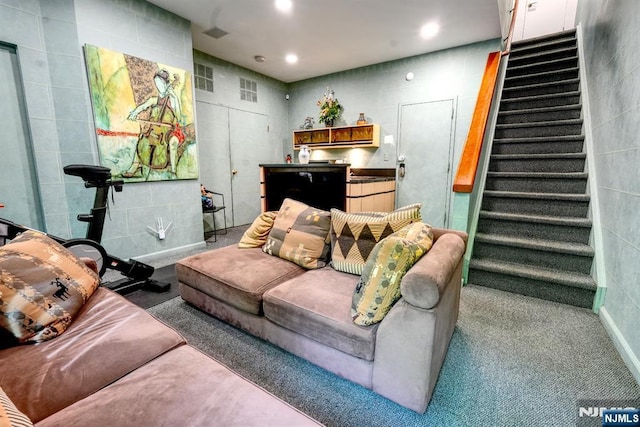 living room featuring stairway, tile walls, and recessed lighting