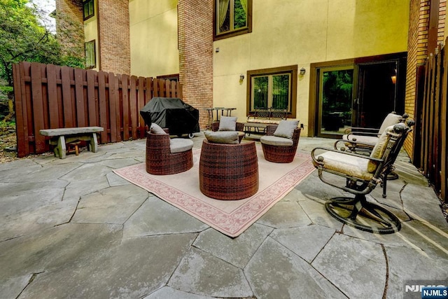view of patio featuring a grill, fence, and an outdoor hangout area