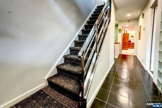 stairs with tile patterned flooring and baseboards
