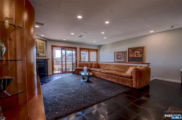 living room featuring a fireplace with flush hearth, baseboards, and recessed lighting
