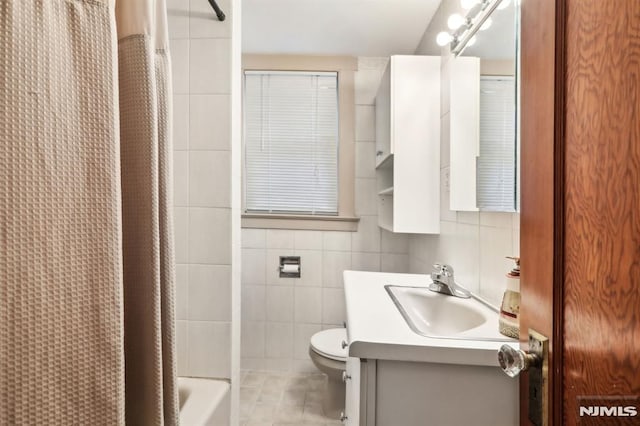 12-67 12th St, Fair Lawn, NJ 07410 - full bathroom with toilet, vanity, tile patterned flooring, tile walls, and shower / bath combo