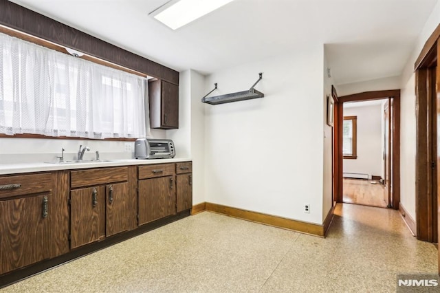 12-67 12th St, Fair Lawn, NJ 07410 - kitchen featuring baseboards, a sink, light countertops, and dark brown cabinetry