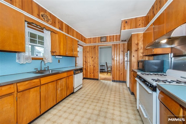 kitchen featuring white appliances, a sink, under cabinet range hood, and brown cabinets