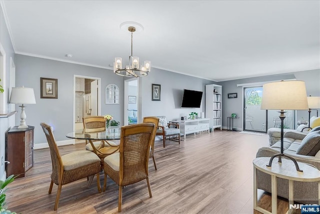 dining room with a chandelier, wood finished floors, crown molding, and baseboards