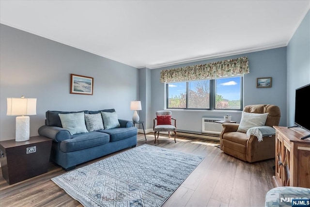 living room with ornamental molding, a wall unit AC, and wood finished floors