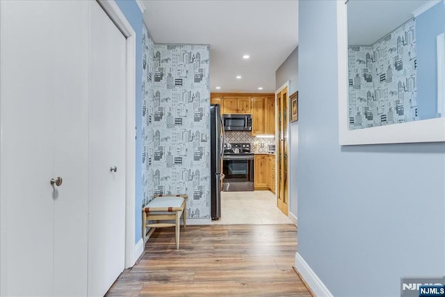 corridor with light wood-style flooring, recessed lighting, and baseboards