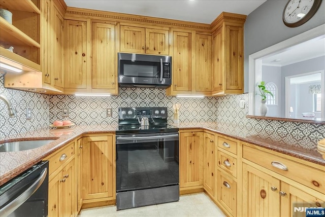 kitchen with appliances with stainless steel finishes, a sink, light tile patterned flooring, tasteful backsplash, and light stone countertops