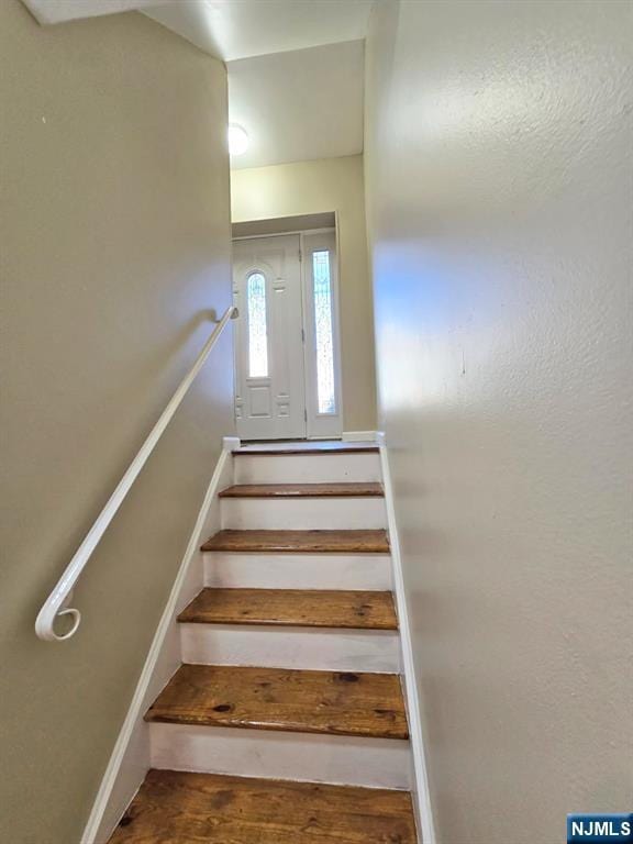 stairs featuring wood finished floors