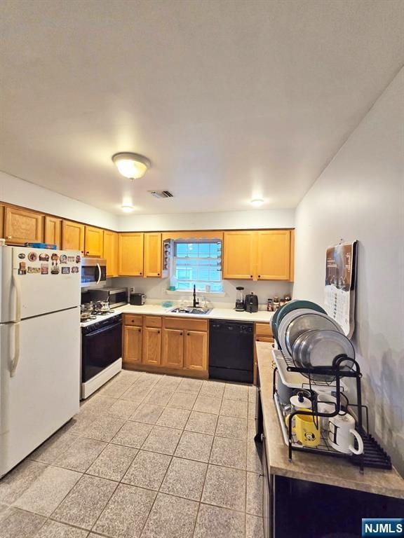 kitchen featuring white appliances, a sink, and light countertops