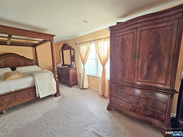 bedroom with light colored carpet and baseboards