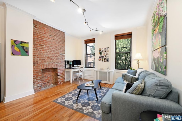 204 Washington St Unit 2B, Jersey City, NJ 07302 - living room featuring radiator, wood finished floors, a fireplace, a desk, and baseboards