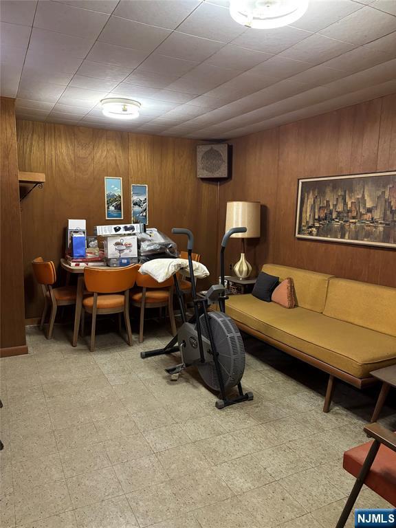 living room with wood walls and tile patterned floors