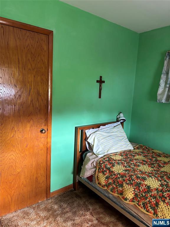 bedroom featuring carpet and baseboards