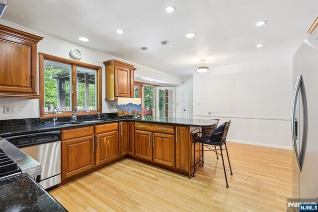 20 Old Farm Rd, Caldwell, NJ 07006 - kitchen featuring appliances with stainless steel finishes, light wood-type flooring, a peninsula, a sink, and brown cabinets