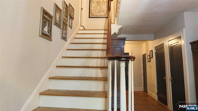 stairs featuring baseboards and wood finished floors