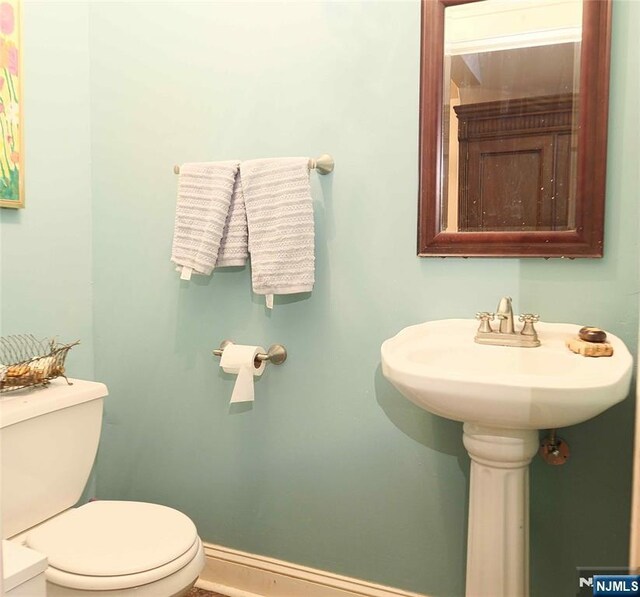 half bath with toilet and baseboards