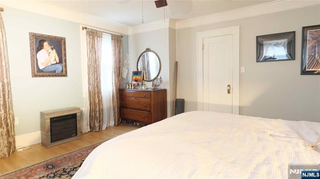 bedroom featuring wood finished floors, crown molding, and a ceiling fan