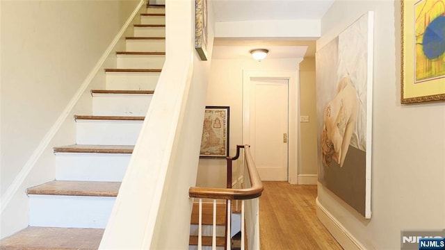 stairs featuring wood finished floors